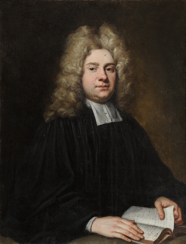 A portrait of a white man with a typical long grey 17th century wig, sitting at a desk with an open book