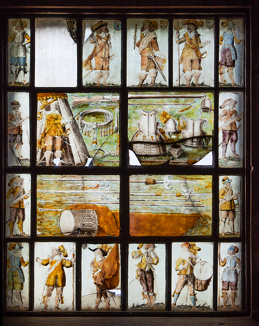 A stained glass panel showing royalist soldiers with drums and pipes